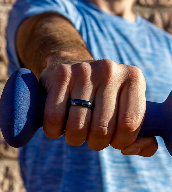 A close-up of a person's hand gripping a blue dumbbell, wearing a simple the Zirconia Ceramic Payment Ring on the ring finger.